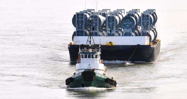 Custom-designed barges transported 10 sets of wind tower components at once.